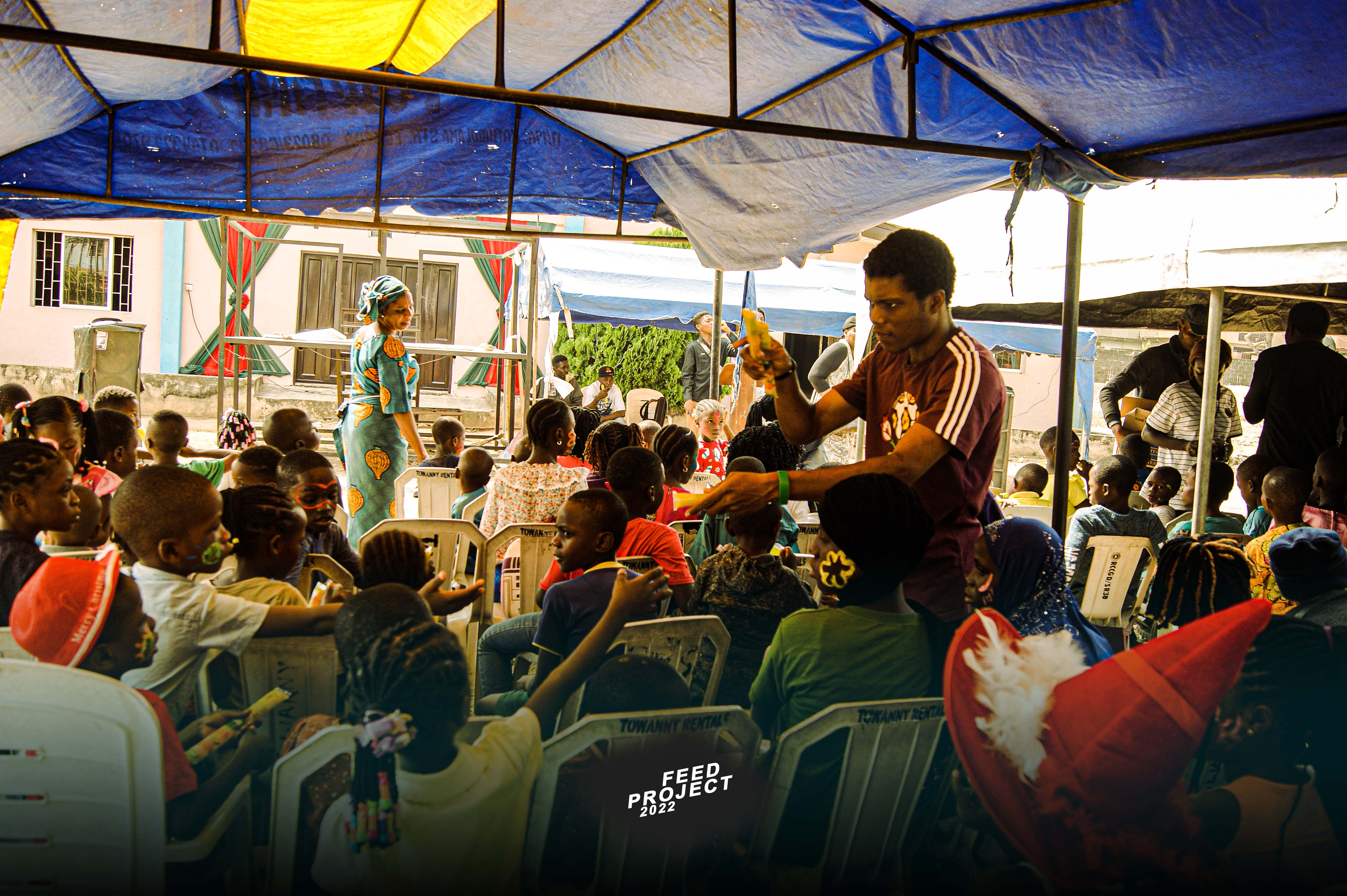 Children gathered at a FEED PROJECT community outreach